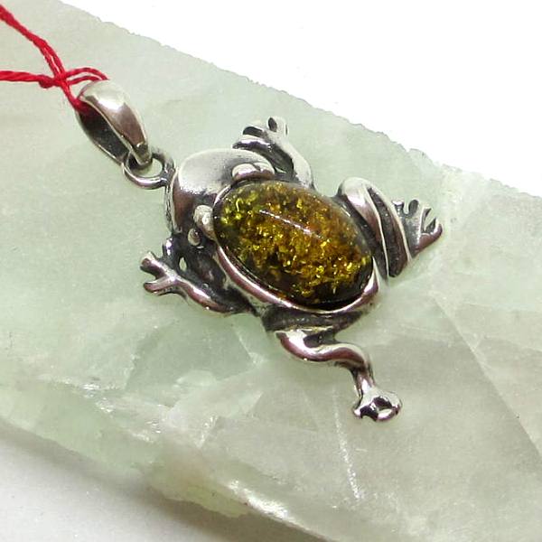 Ce pendentif en ambre représentant une grenouille est un bijoux sur argent 925 millième.